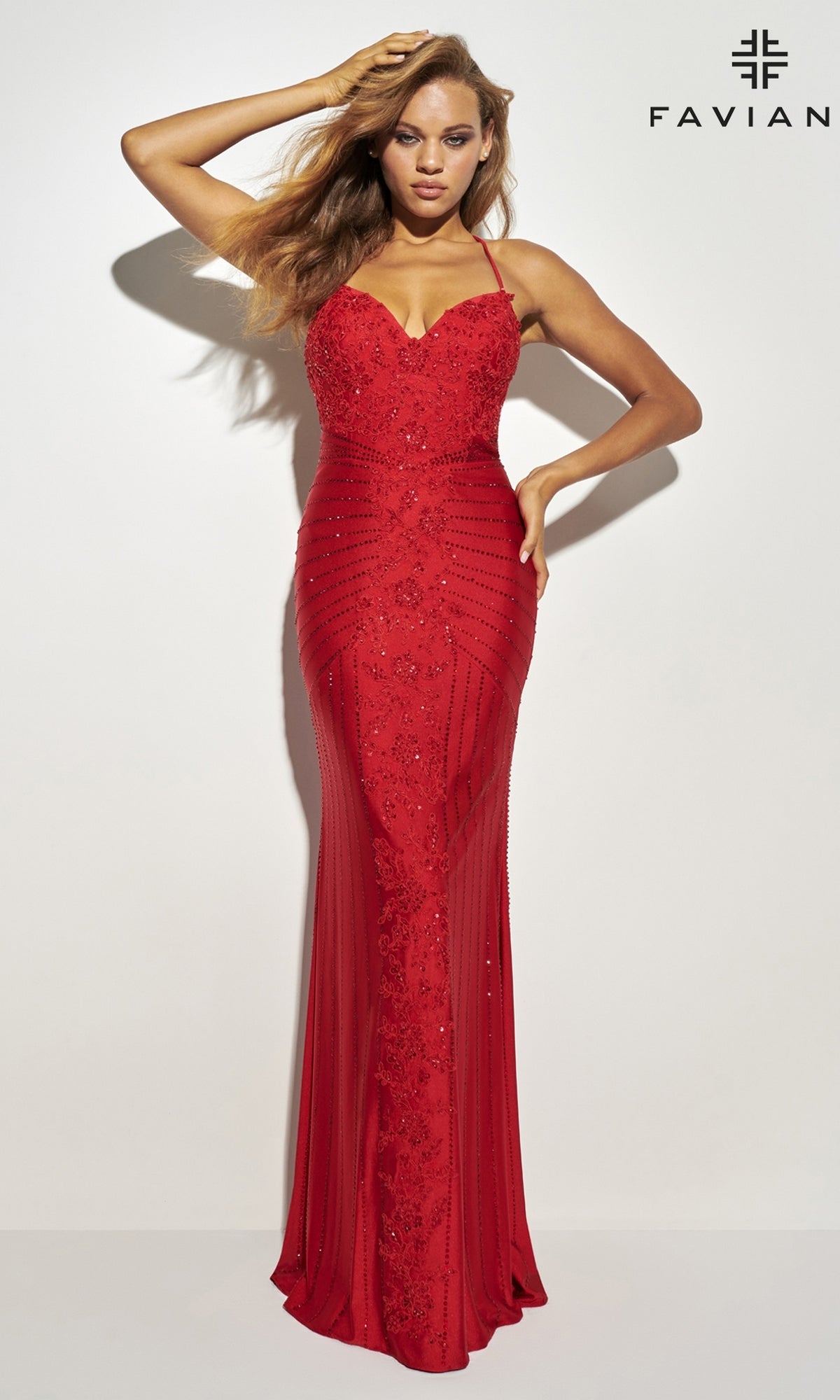 A woman poses against a plain white background wearing the fitted, floor-length Lace-Up Long Faviana Beaded Prom Dress 11021, featuring shimmering embellishments. The FAVIANA logo appears in the top right corner.